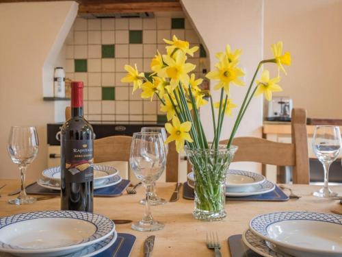 a table with a bottle of wine and yellow flowers at 4 Bed in Patterdale SZ170 in Patterdale