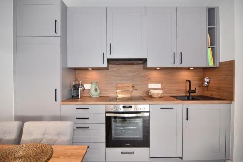 uma cozinha com armários brancos e um forno com placa de fogão em Alice, Whg 9, 1 OG em Westerland