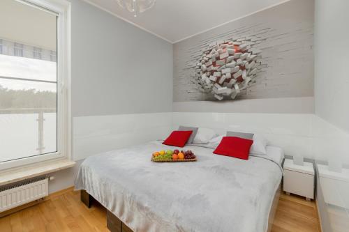 een slaapkamer met een bed met een fruitschaal erop bij Lilly Aquamarina SeaView by Rent like home in Międzyzdroje