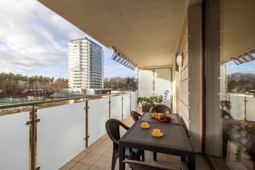 een balkon met een tafel en stoelen in een gebouw bij Lilly Aquamarina SeaView by Rent like home in Międzyzdroje
