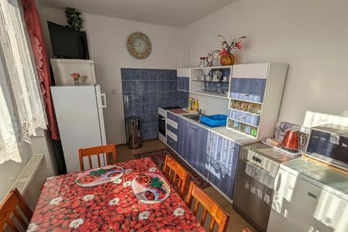 eine kleine Küche mit einem Tisch und einem Kühlschrank in der Unterkunft Vila Imagina in Ratboř