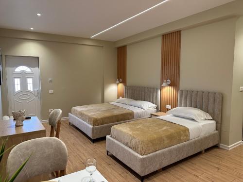 a hotel room with two beds and a table and chairs at Arial Lofts in Vlorë