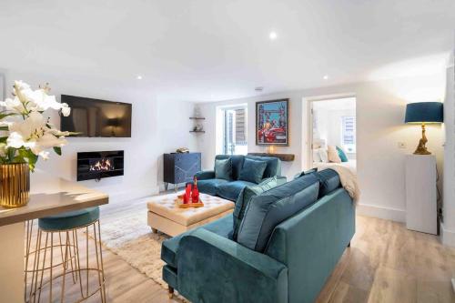 a living room with a blue couch and a fireplace at Wanstead, Escape London in London-Luxury 2 Bed in London