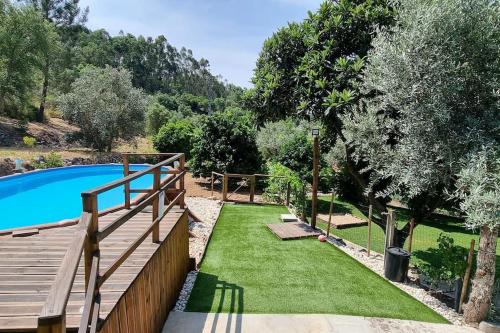 a garden with a swimming pool and a wooden fence at Casa do Riu in Santiago de Montalegre