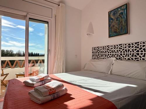 een slaapkamer met een groot bed en 2 handdoeken bij Casas Plus Costa Brava in L'Estartit