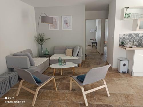 uma sala de estar com um sofá, cadeiras e uma mesa em Patio de Lea (web) em Mons