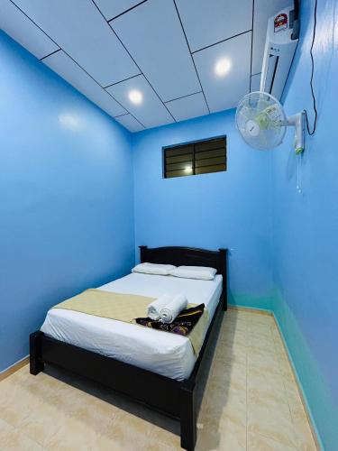 a blue bedroom with a bed in a room at Sena Yang Indah Homestay in Kangar