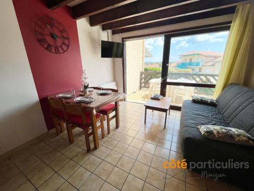 un salon avec une table et un canapé dans l'établissement Le Poséidon 56 - Apt T3 à deux pas de l'Océan, à Mimizan