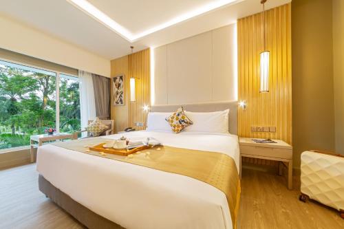 een hotelkamer met een groot bed en een raam bij Glenmarie Hotel and Golf Resort in Shah Alam