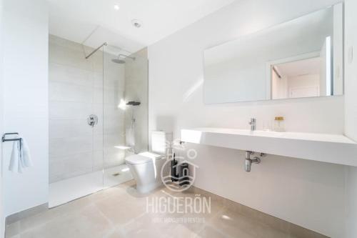 Un baño blanco con inodoro y lavabo. en HigueronRentals Twin apartments, en Málaga