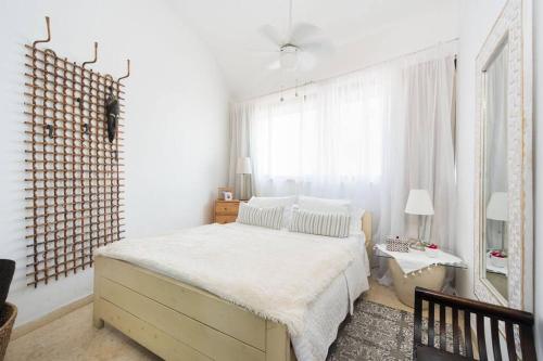 a white bedroom with a bed and a window at Charming New Apt in Jaffa Near Sea in Tel Aviv