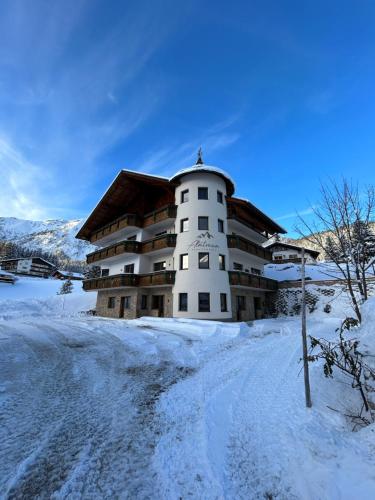 a large building in the snow with snow covered ground at Almtraum Berwang in Berwang
