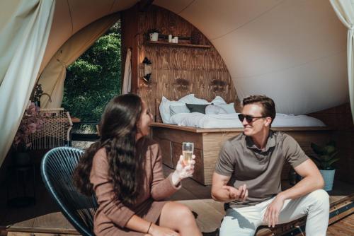 a man and a woman sitting in a tent at deichkind country loft in Achim