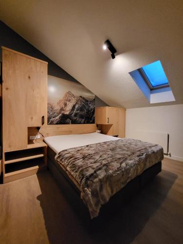 a bedroom with a large bed with a window at Almtraum Berwang in Berwang