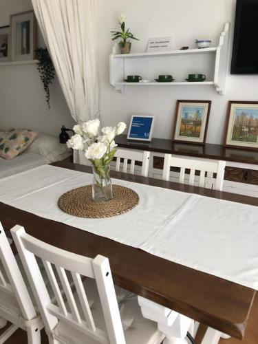ein Esstisch mit einer Vase mit Blumen darauf in der Unterkunft PRIMERA LINEA PEÑISMAR in Peñíscola