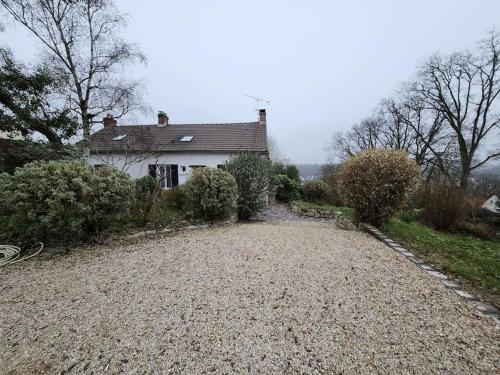 a house with a gravel driveway in front of it at Magnifique maison au cœur d'un jardin paysager in Breuillet