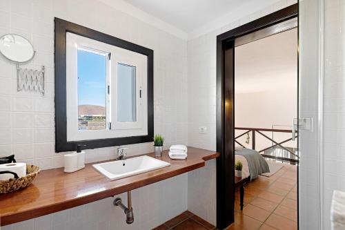 een witte badkamer met een wastafel en een raam bij Finca Emblemática - Nº6 Timbayba in La Vegueta