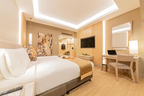 a bedroom with a bed and a desk and a computer at Glenmarie Hotel and Golf Resort in Shah Alam