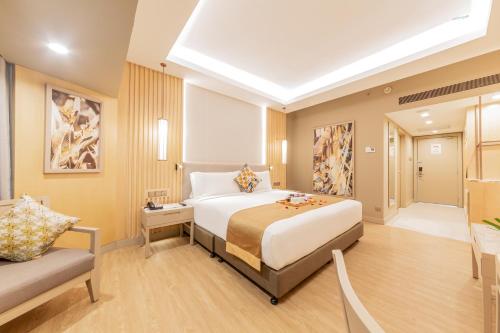a bedroom with a large bed and a couch at Glenmarie Hotel and Golf Resort in Shah Alam