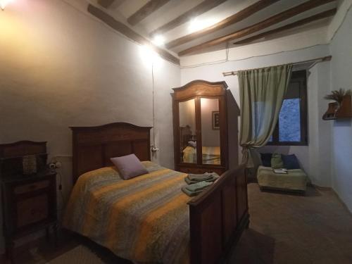 a bedroom with a large bed and a mirror at Ca l'Aleixa Rooms in Bisbal de Falset