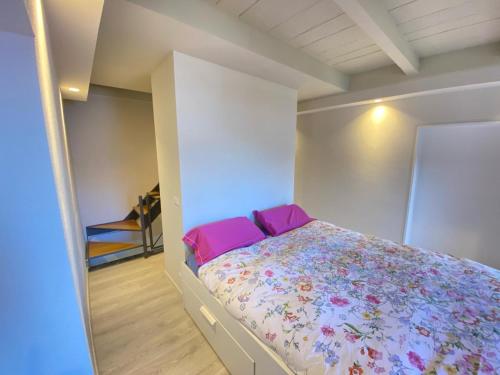 a bedroom with a bed with pink pillows at Casa Spasù in San Bartolomeo