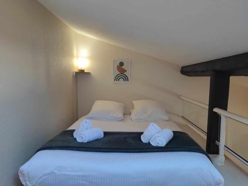 1 dormitorio con 1 cama con 2 toallas en Charme de Victor ConciergerieDameCarcas en Carcasona