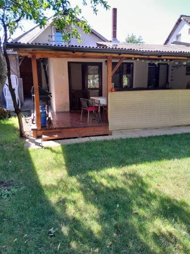 a house with a wooden deck with a table at Olga house Deva in Deva