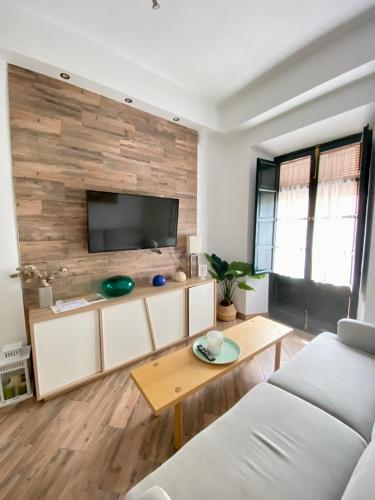 ein Wohnzimmer mit einem Sofa und einem Tisch in der Unterkunft Apartamento 4pax en pleno centro Alfalfa in Sevilla