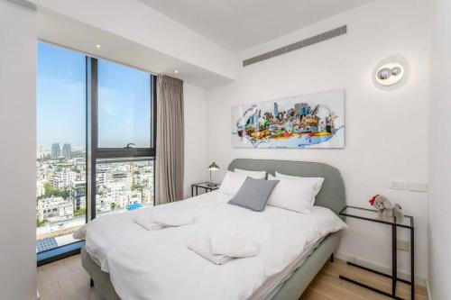 a bedroom with a white bed with a large window at MAMAD High Standard 3BR Gymnasia Parking Sea view in Tel Aviv