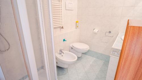 een witte badkamer met een toilet en een wastafel bij Al Bivio Peschiera - Italian Homing in Peschiera del Garda