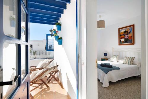 una camera con letto e un balcone con soffitti blu di La Chinija a Playa Honda