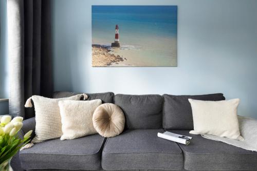 a living room with a gray couch with a lighthouse at Elite Apartments Marine Suite in Gdańsk