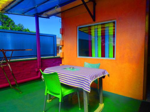 een tafel en stoelen op een balkon met een kleurrijke muur bij B.Rose House in Hatton
