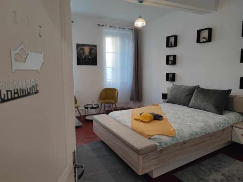 um quarto com uma cama com um cobertor amarelo em Le Cœur Familial em Carcassonne