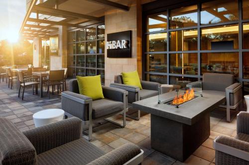 a restaurant with couches and chairs and a fire pit at Hyatt House San Jose/Cupertino in Cupertino