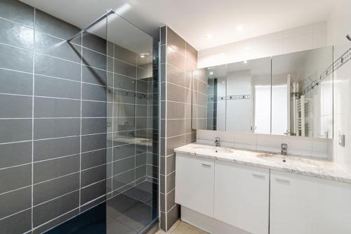 une salle de bain avec deux lavabos et une douche dans l'établissement Chez Viviane appartement parking/ Classé 4 *, à La Ciotat