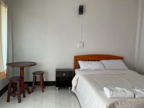 a bedroom with a bed and a table and two stools at Bansuan viewpai in Pai