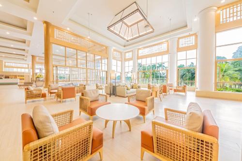 a lobby with chairs and tables and windows at Glenmarie Hotel and Golf Resort in Shah Alam