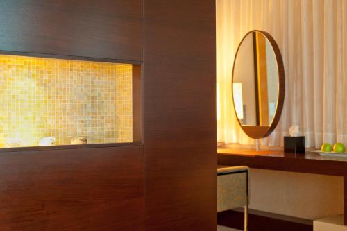 a bathroom with a mirror and a brown cabinet at Dorint Hotel am Heumarkt Köln in Cologne