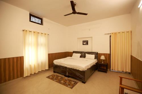 a bedroom with a bed and a ceiling fan at Awadh Punch Garden Cafe in Lucknow