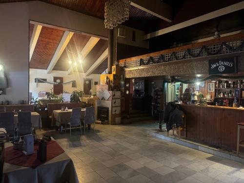 um restaurante com mesas e cadeiras e um bar em Мотел Тихия кът em Sófia