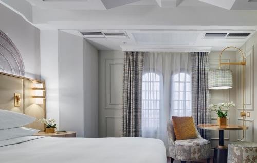 a bedroom with a bed and a chair and a window at Hilton Molino Stucky Venice in Venice