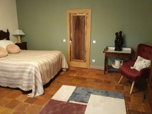 une chambre avec un lit, une chaise et une table dans l'établissement gîte Les Iris 3 étoiles 47 RUFFIAC, à Ruffiac