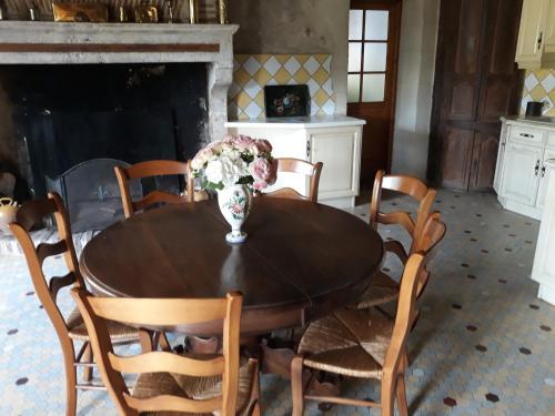 une table de salle à manger avec un vase de fleurs dessus dans l'établissement gîte Les Iris 3 étoiles 47 RUFFIAC, à Ruffiac