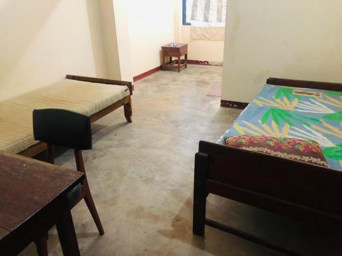 a room with two beds and a table and chairs at PCU in Trincomalee