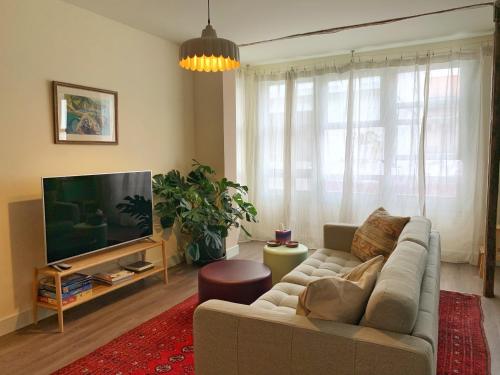 a living room with a couch and a flat screen tv at Charming flat in historic centre by Santa Maria in Bermeo