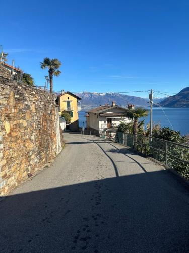 a road next to a stone wall with a house at Casa Spasù in San Bartolomeo