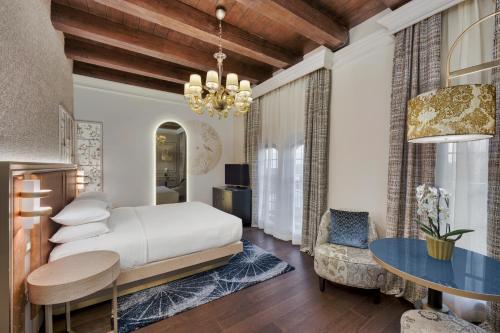 a bedroom with a bed and a table at Hilton Molino Stucky Venice in Venice