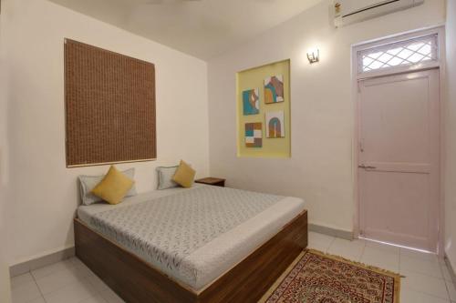 1 dormitorio con cama, ventana y puerta en Calangute Cosy 1 bhk Apartment en Calangute