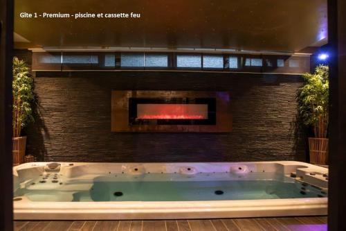 a bath tub in a room with a fireplace at Suite Wellness in Sprimont